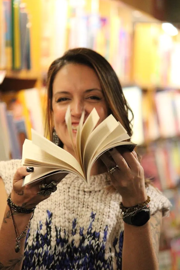Jholy Mello folheando o livro CRM no Varejo numa livraria