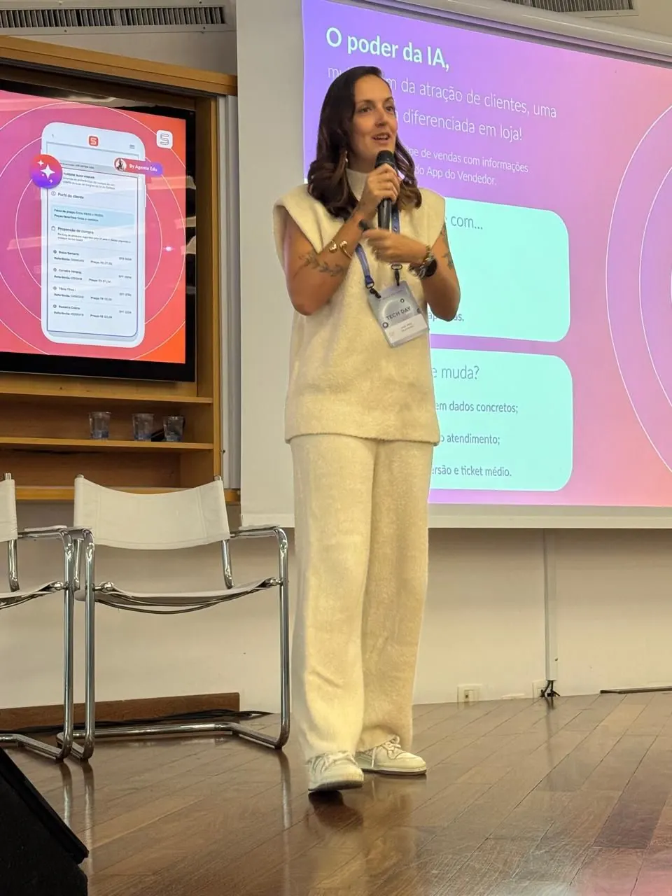 Jholy Mello na palestra "O poder da IA", com microfone e slides projetados