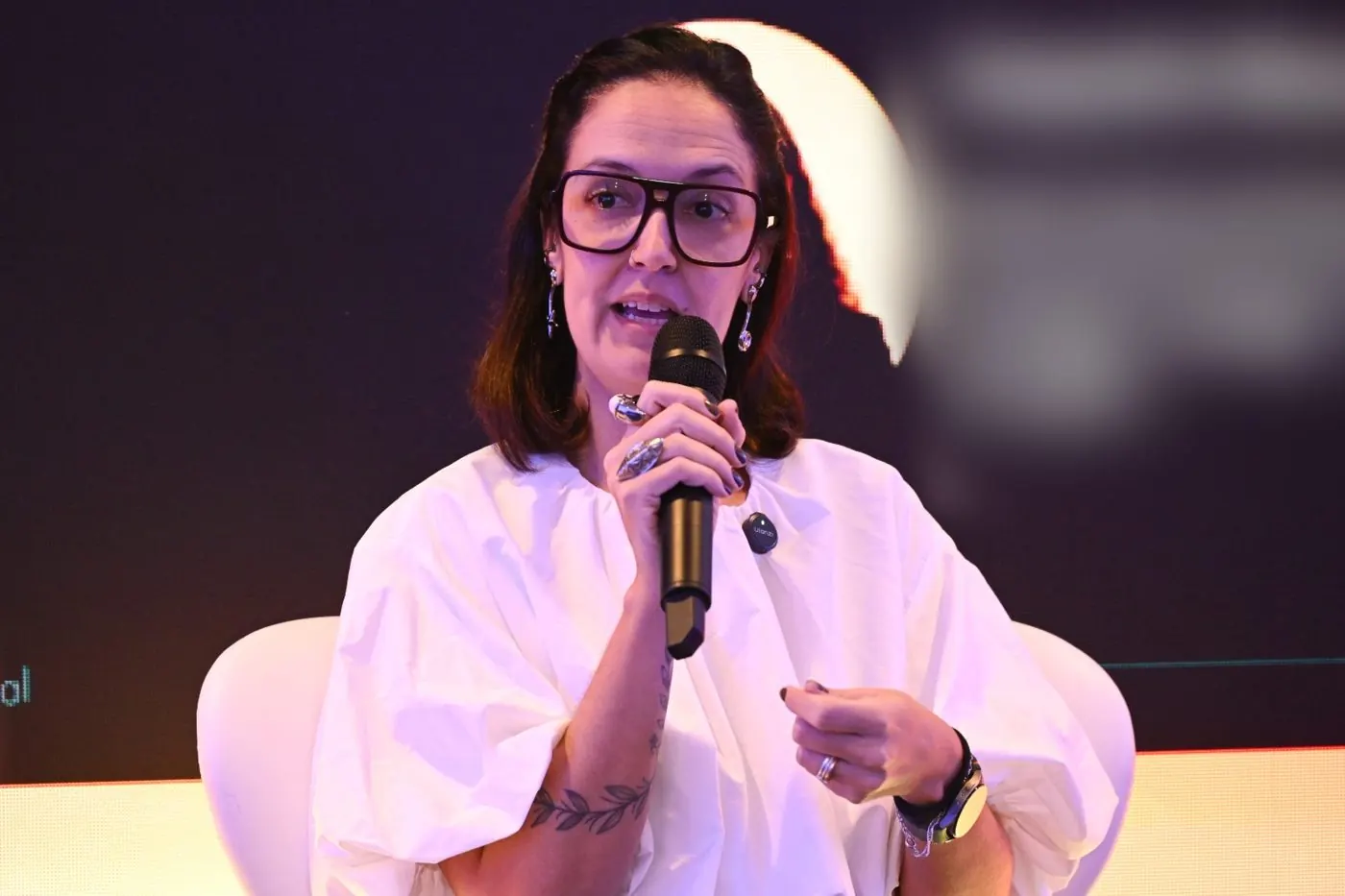Jholy Mello falando ao microfone na roda de conversa CRM e Governança de Dados
