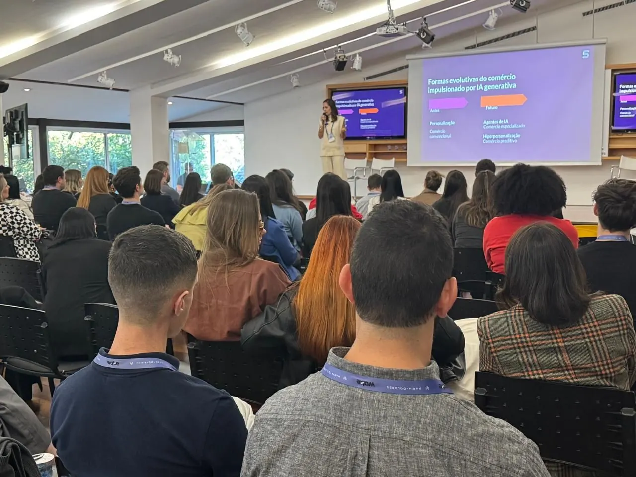 Auditório lotado assistindo a uma palestra de Jholy Mello